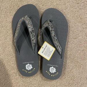 Gray yellow box flip flops that have never been worn.